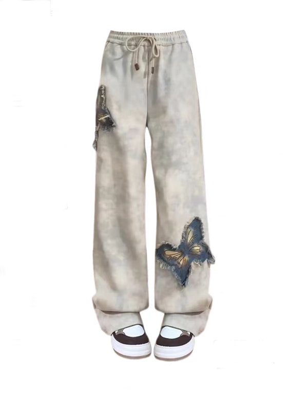 Y2K low-rise sweatpants with glowing butterfly patches and 2000s sport stripes